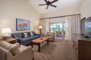 a living room with a couch and a tv at Kona Coast Resort in Kailua-Kona