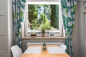 a dining room with a table and a window at Orbisa Pokoje i Apartamenty w cenie Parking Rowery Klimatyzacja opcja Śniadań in Łeba