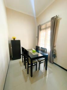 a dining room with a black table and chairs at Vila Diamond Batu in Songgoriti
