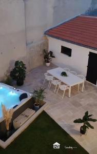 eine Terrasse mit einem Tisch und einem Pool in der Unterkunft villa_lumiere_la_rochelle avec spa à 800m de l'océan in La Rochelle