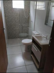 y baño con aseo, ducha y lavamanos. en Pousada Pontal Jurerê, en Florianópolis