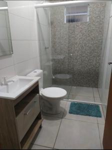 y baño con ducha, aseo y lavamanos. en Pousada Pontal Jurerê, en Florianópolis