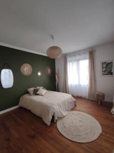 ein Schlafzimmer mit einem Bett und einer grünen Wand in der Unterkunft villa_lumiere_la_rochelle avec spa à 800m de l'océan in La Rochelle
