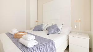 a white room with a bed with towels on it at Residenza Excelsior - Bilocali Piano Terra in Marina di Montenero +164 photos