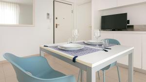 a dining room table with two chairs and a tv at Residenza Excelsior - Bilocali Piano Terra in Marina di Montenero