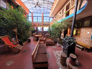a room with benches and tables and plants at La Minga Hostal in Salinas