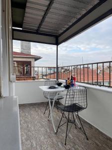eine Terrasse mit einem Tisch und Stühlen auf dem Balkon in der Unterkunft PANORAMA CITY SUITE in Istanbul