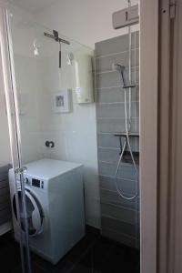 een badkamer met een wasmachine en een douche bij Ferienunterkunft im Tegelhaus in Berlijn