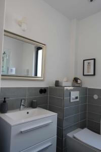 La salle de bains est pourvue d'un lavabo, d'un miroir et de toilettes. dans l'établissement Ferienunterkunft im Tegelhaus, à Berlin