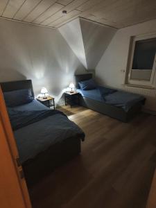 a bedroom with two beds and two lamps on tables at Haus Tanja in der Kurstadt Bad Eilsen in Bad Eilsen