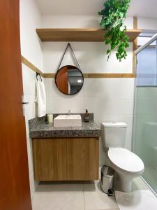 a bathroom with a sink and a toilet and a mirror at Acolhedor 2 quartos em ipiabas in Barra do Piraí