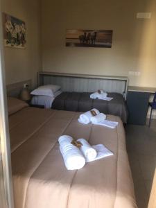 a hotel room with two beds with towels on them at Gerberarooms in Pozzilli