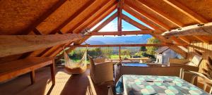 a room with a table and a hammock on a roof at Gite la Montagnette in Ruffieux