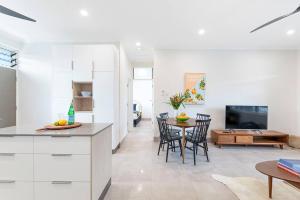 a kitchen and living room with a table and chairs at 'Botanica Paradiso' A Vibrant Nightcliff Solace in Nightcliff