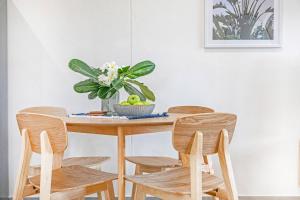 a dining room table with four chairs and a plant at 'Botanica Hoja' A Nightcliff Balcony Refresh in Nightcliff