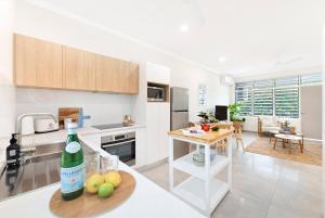 a kitchen with a bottle of wine on a table at 'Botanica Hoja' A Nightcliff Balcony Refresh in Darwin