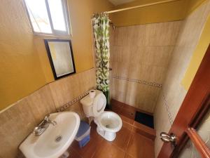 a small bathroom with a sink and a toilet at La Minga Hostal in Salinas