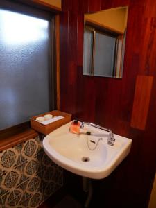 y baño con lavabo blanco y espejo. en 駅前宿舎 禪 shared house zen, en Eiheiji