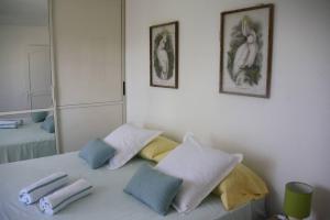 sypialnia z łóżkiem z poduszkami i lustrem w obiekcie Apt 2 chambres Vue Lagon w mieście Saint-Martin