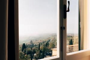 ein offenes Fenster mit Talblick in der Unterkunft Hotel San Luca in Cortona