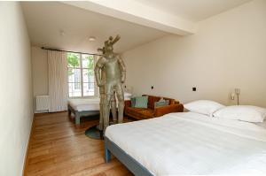 a bedroom with two beds and a statue in the middle at Hotel in het huis van Deventer in Deventer