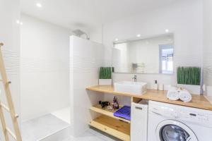 a bathroom with a washing machine and a sink at LES PIEDS DANS L'EAU VUE EXCEPTIONNELLE SUR LA MER in Marseille