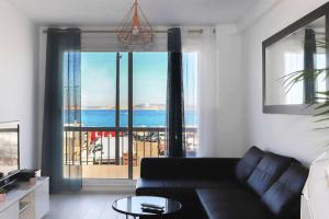 a living room with a couch and a view of the ocean at LES PIEDS DANS L'EAU VUE EXCEPTIONNELLE SUR LA MER in Marseille