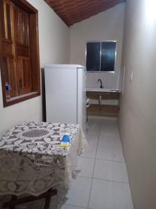 uma cozinha com um frigorífico, uma mesa e um lavatório em Kitnete Aconchegante em Itacaré