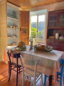 BorzonascaにあるLa casa con giardino tra borghi, boschi cascate e naturaのキッチン(テーブル、椅子付)、窓