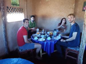 een groep mensen die rond een tafel zitten bij Sahara Peace camp in Zagora