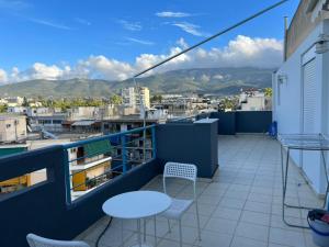 d'un balcon avec des tables et des chaises offrant une vue sur la ville. dans l'établissement Elvita Apartments 2, à Athènes