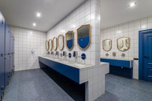Baño con una fila de lavabos y espejos en Emily Magic Hostel en Vynnyky