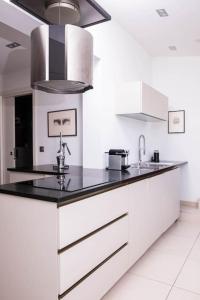 een keuken met witte kasten en een zwart aanrecht bij L'Appartement des Artistes avec Terrasse in Kaysersberg