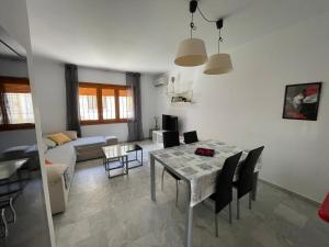 a dining room and living room with a table and chairs at APARTAMENTO VERA playa in Vera