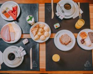 une table avec des assiettes de nourriture et des tasses de café dans l'établissement Hotel Minas Gerais, à Poços de Caldas