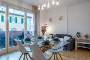 een eetkamer met een glazen tafel en witte stoelen bij Art Design Home Firenze in Florence