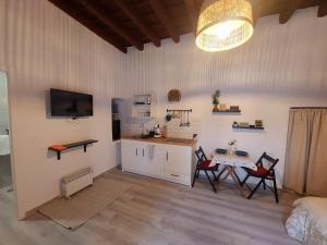 sala de estar con mesa y cocina con TV. en Apartamento Bulería, en Jerez de la Frontera
