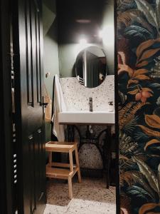 ein Bad mit einem Waschbecken, einem Spiegel und einem Stuhl in der Unterkunft Cottage43 in Bărcuţ