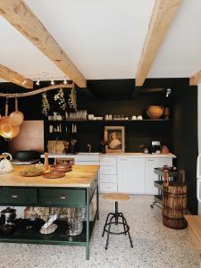 eine Küche mit schwarzen Wänden und einem Holztisch in der Unterkunft Cottage43 in Bărcuţ