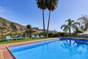 una grande piscina con palme e sedie di Group Villa 14 Pool wifi Air a Frigiliana