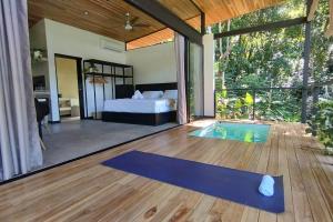 Schlafzimmer mit einem Bett und einer blauen Yogamatte in der Unterkunft Casa Sol y Luna, Santa Teresa in Playa Santa Teresa