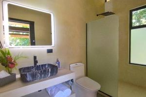 a bathroom with a sink and a toilet and a mirror at Casa Sol y Luna, Santa Teresa in Santa Teresa Beach