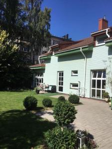 Cette grande maison blanche dispose d'une terrasse dans la cour. dans l'établissement New House, Private Garden & Parking City Center, à Klaipėda