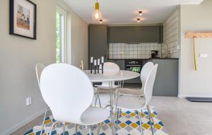 a dining room with a table and white chairs at Guest house on Fäjö in Lyckeby