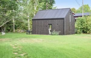 czarna stodoła na polu zielonej trawy w obiekcie Guest house on Fäjö w mieście Lyckeby