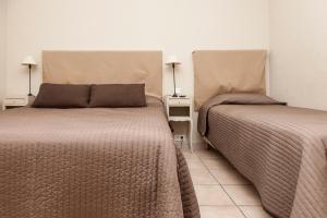 two beds sitting next to each other in a room at Hôtel Les Magnanarelles in Maussane-les-Alpilles