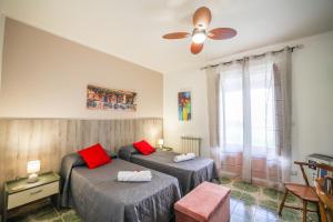 sypialnia z 2 łóżkami i wentylatorem sufitowym w obiekcie B&B Giardino dei Cedri w mieście Trabia