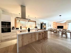 a kitchen with white cabinets and a dining room at Villa Sophie in Lanton