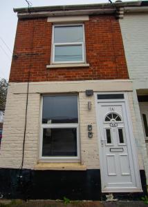 a brick house with a white door and windows at George St Apartment that sleeps up to 4 in Salisbury