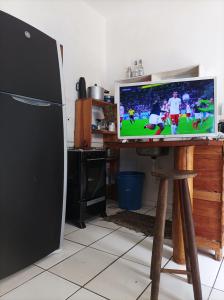 a television sitting on a wooden stand in a kitchen at O Refugio in Mata de Sao Joao